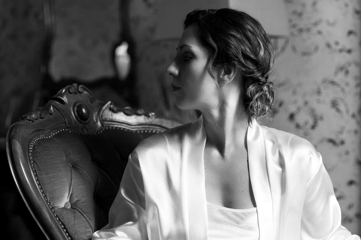 Black and white photo capturing getting ready moments in an elegant setting.