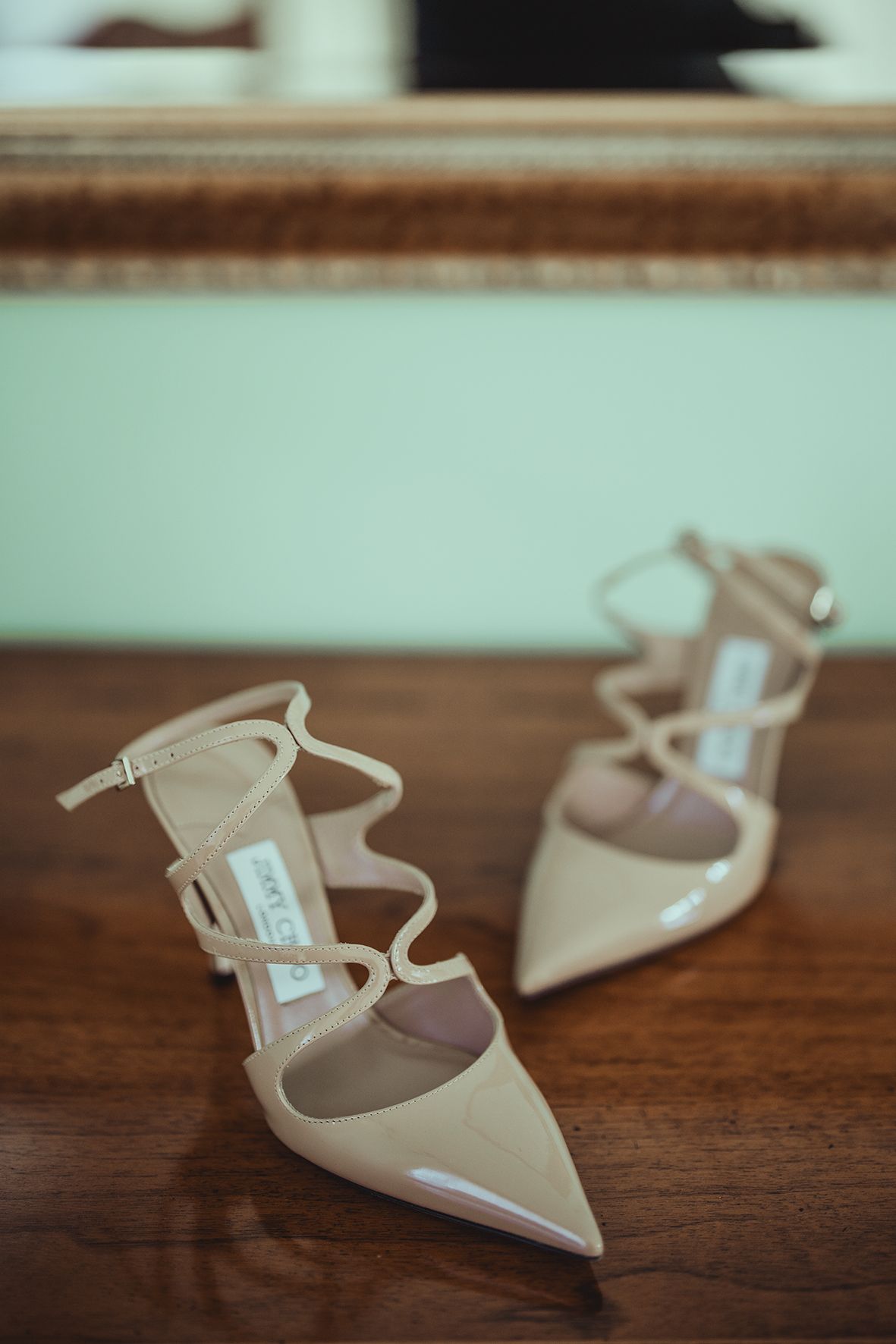 Elegant beige bridal shoes arranged on a wooden surface.