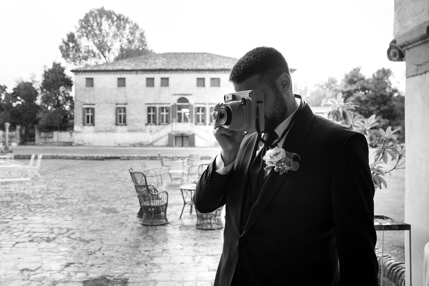 Black and white photo of photographer taking pictures at an elegant venue.