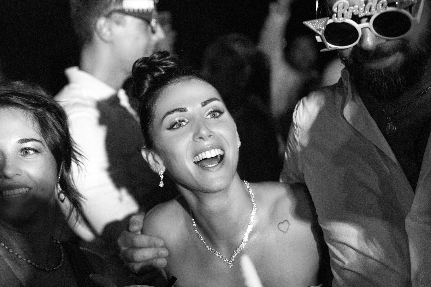 Candid black and white photos capturing joyful moments at a wedding reception.