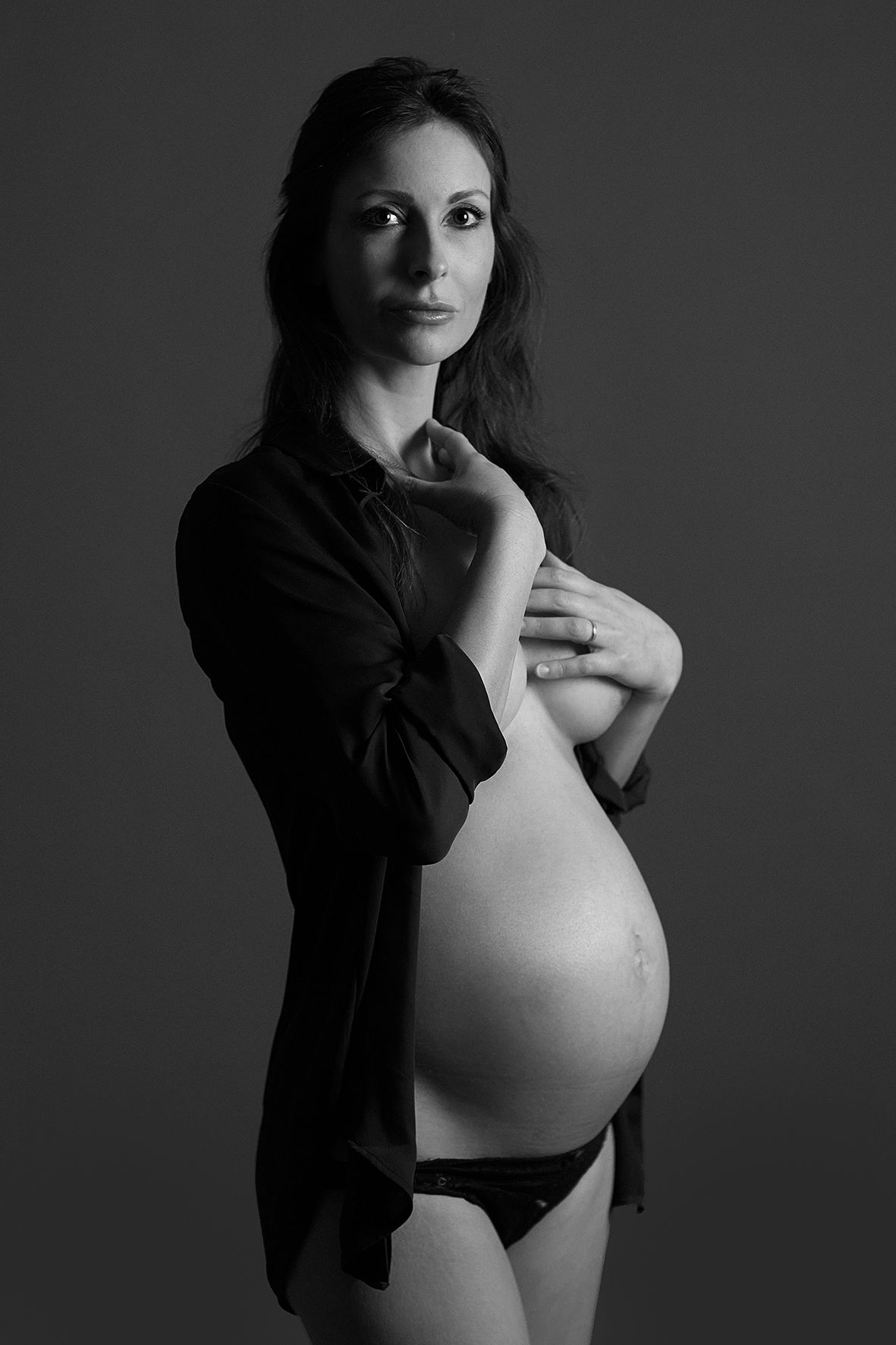 Classic black and white maternity portrait showing pregnancy silhouette.
