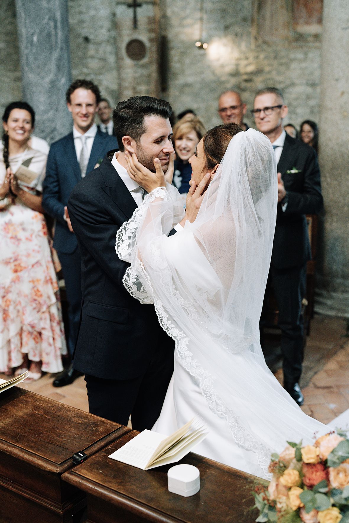 Wedding couple sharing intimate moment at altar during church ceremony.