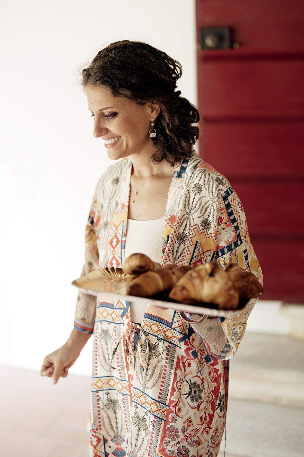 Person wearing patterned dress with floral design moves gracefully in bright interior space.