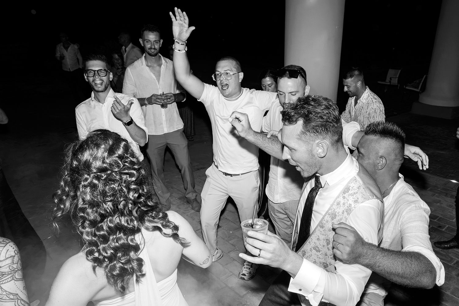 Black and white candid shots of wedding reception dancing and celebrations.