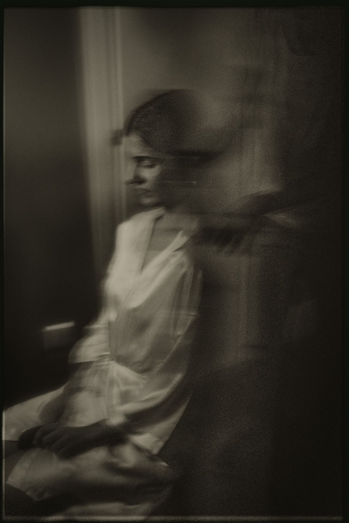 A series of blurry black and white photographs showing a figure in motion creating an ethereal ghostly effect.