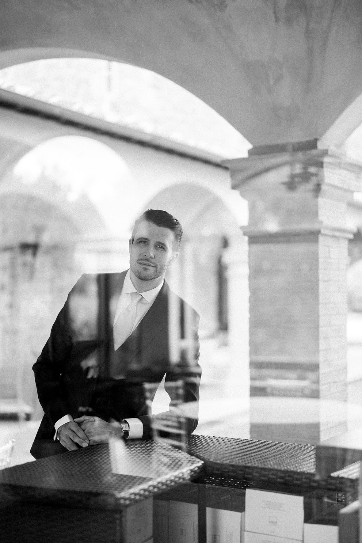 Multiple exposure sequence showing a person sitting at a table under arched architecture.