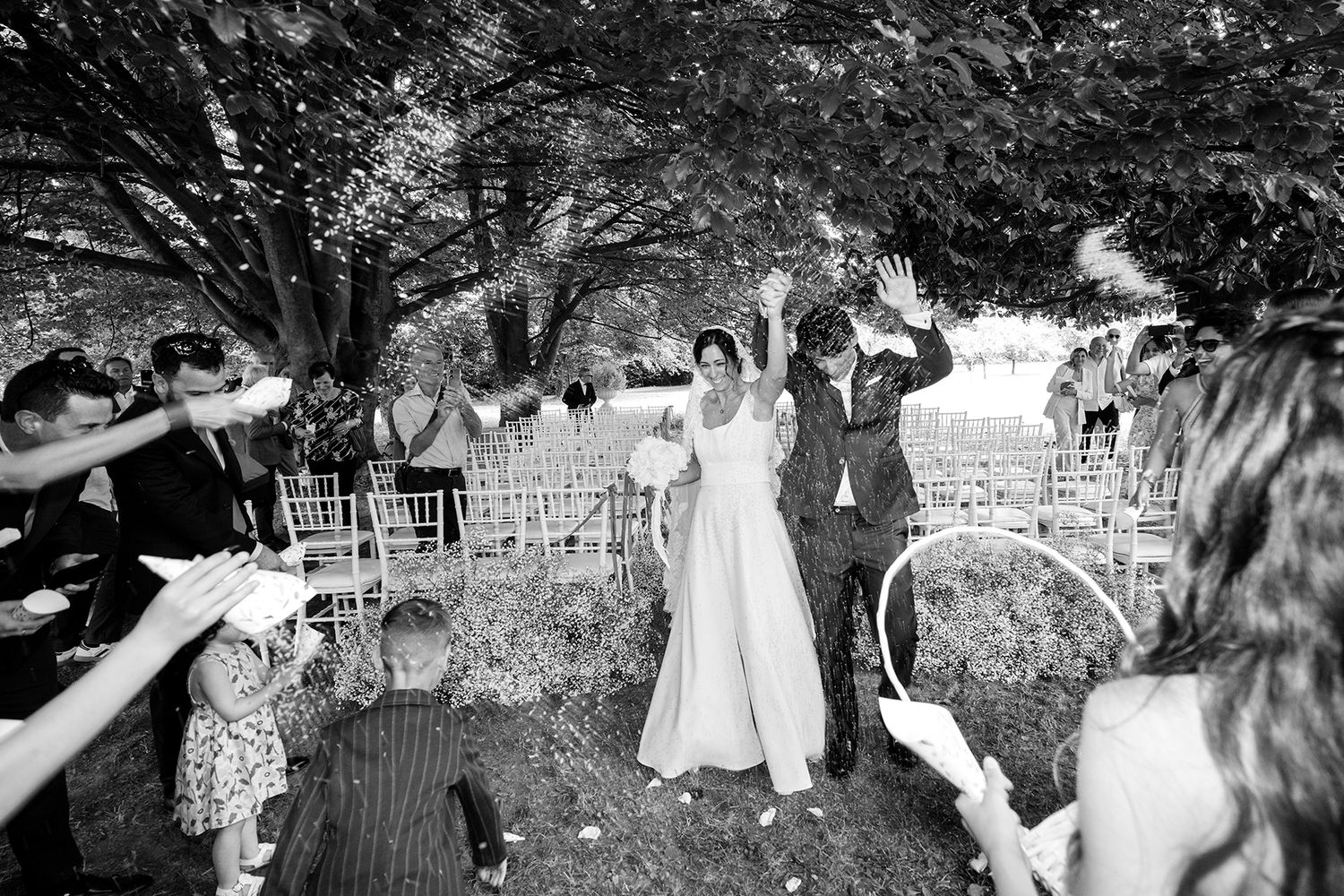 Black and white photos capturing candid moments during outdoor wedding celebration.