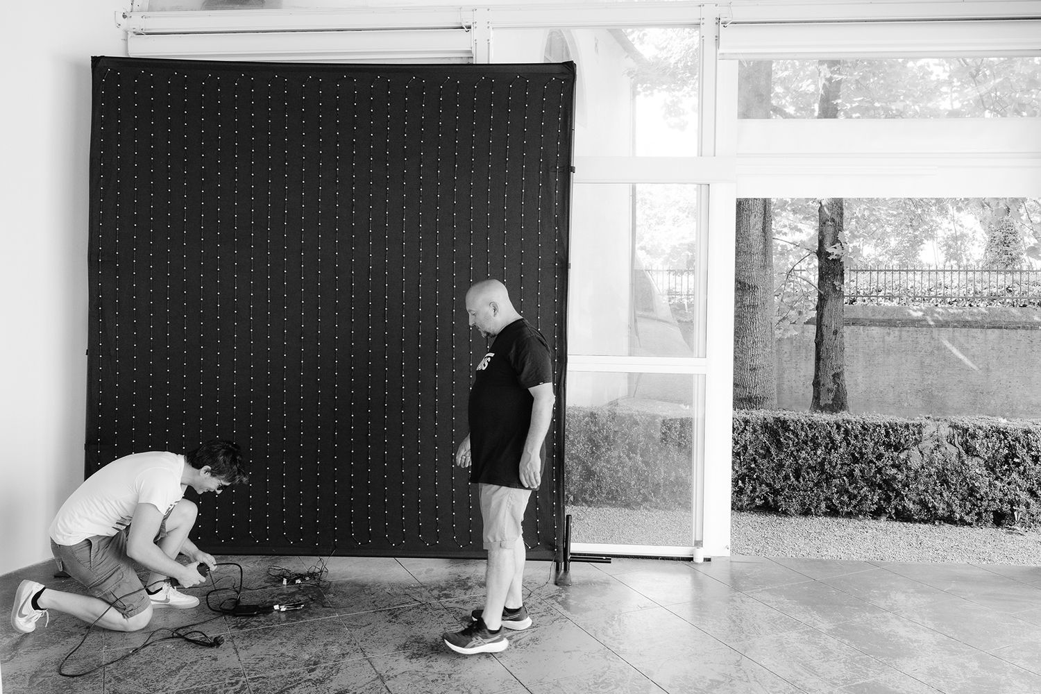 Black and white photo sequence showing two people practicing self-defense moves against a dotted backdrop.