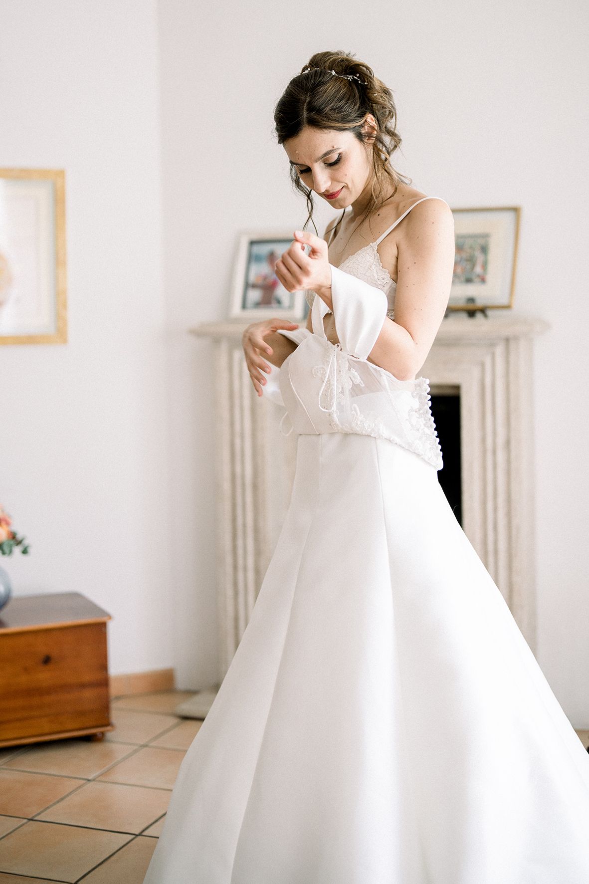 Series showing someone adjusting a white wedding gown in natural light.