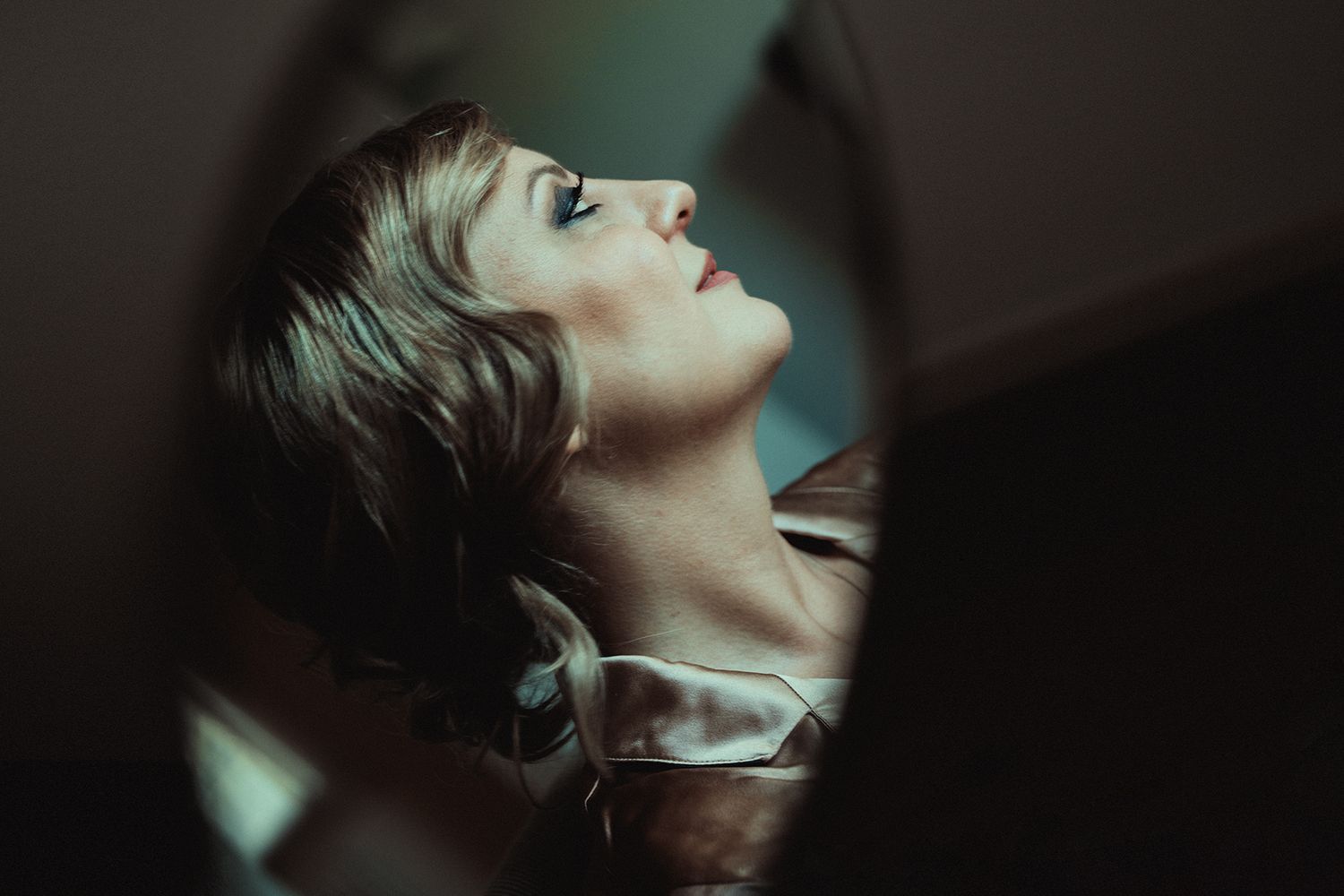 Artistic portrait in dramatic lighting showing upward gaze.