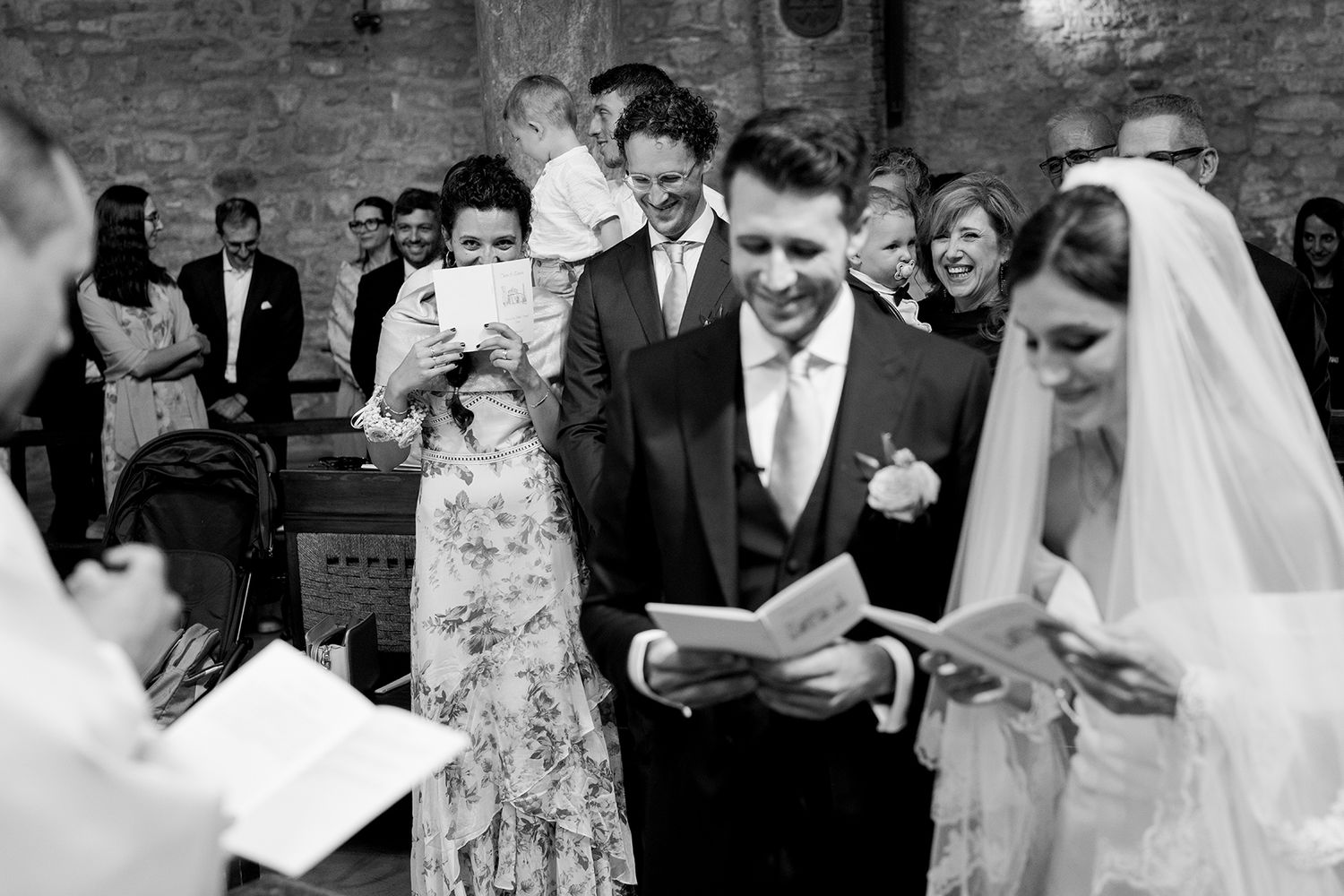 Black and white photo of wedding ceremony in traditional church setting.