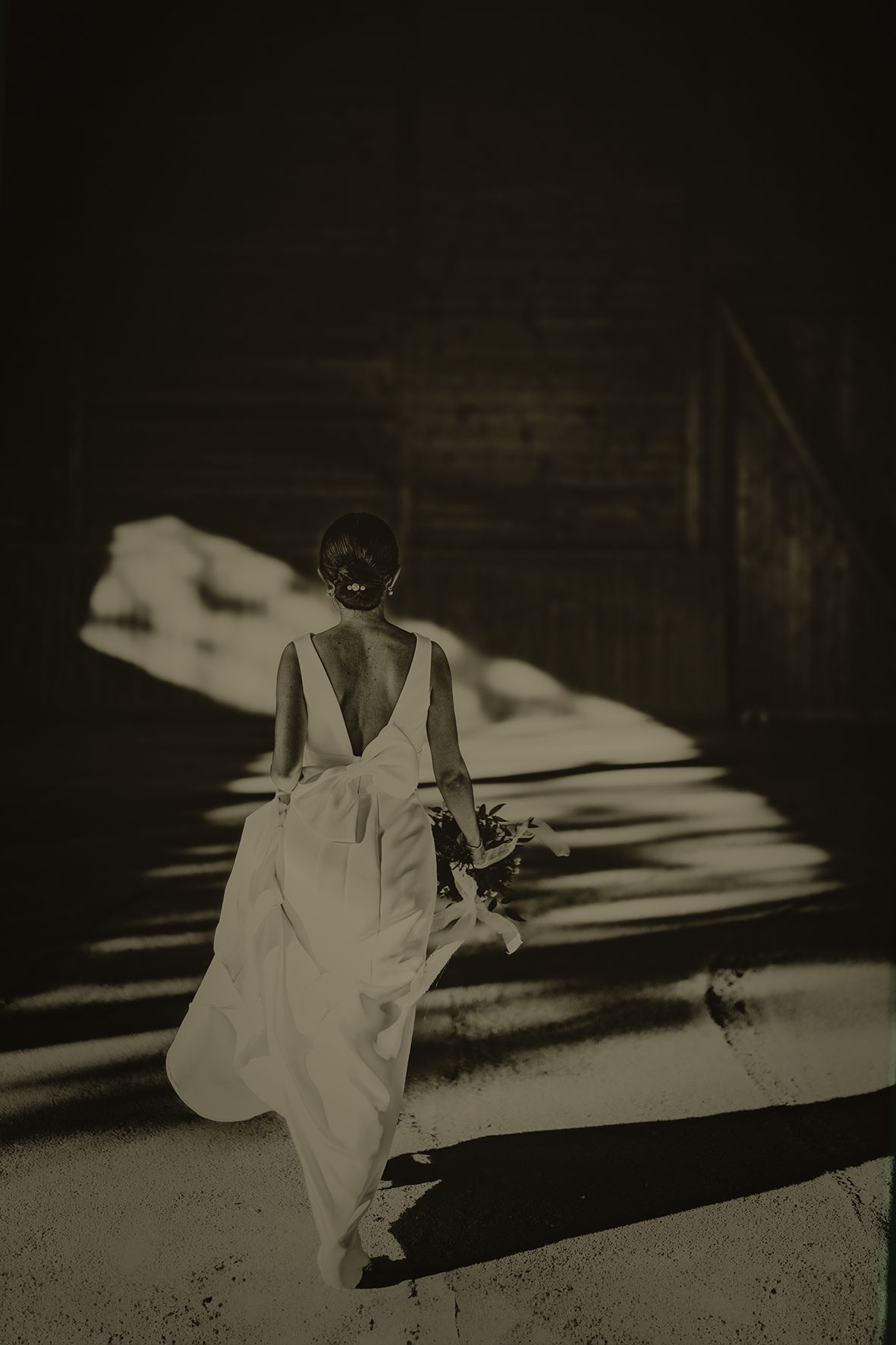 Artistic black and white silhouette of a figure in a white dress casting dramatic shadows.
