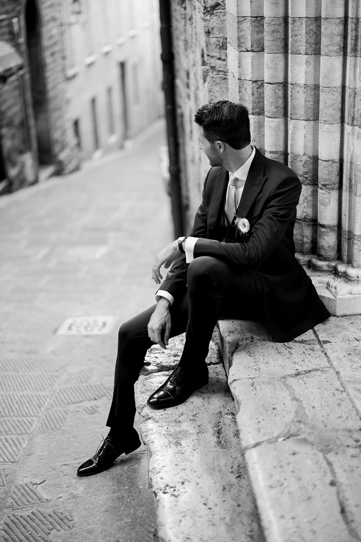 Series of black and white photos showing groom sitting on stone steps in formal attire.