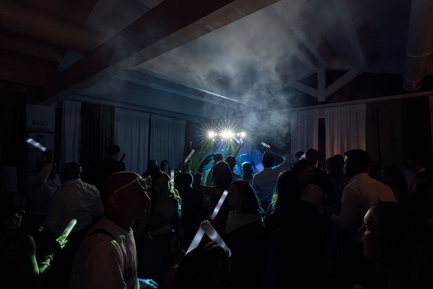 Dark reception venue illuminated with atmospheric blue lighting and fog effects.