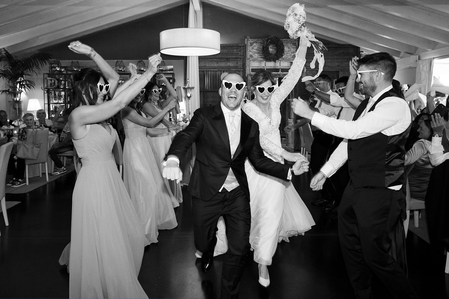 Wedding reception dance party with guests celebrating under a white tent.
