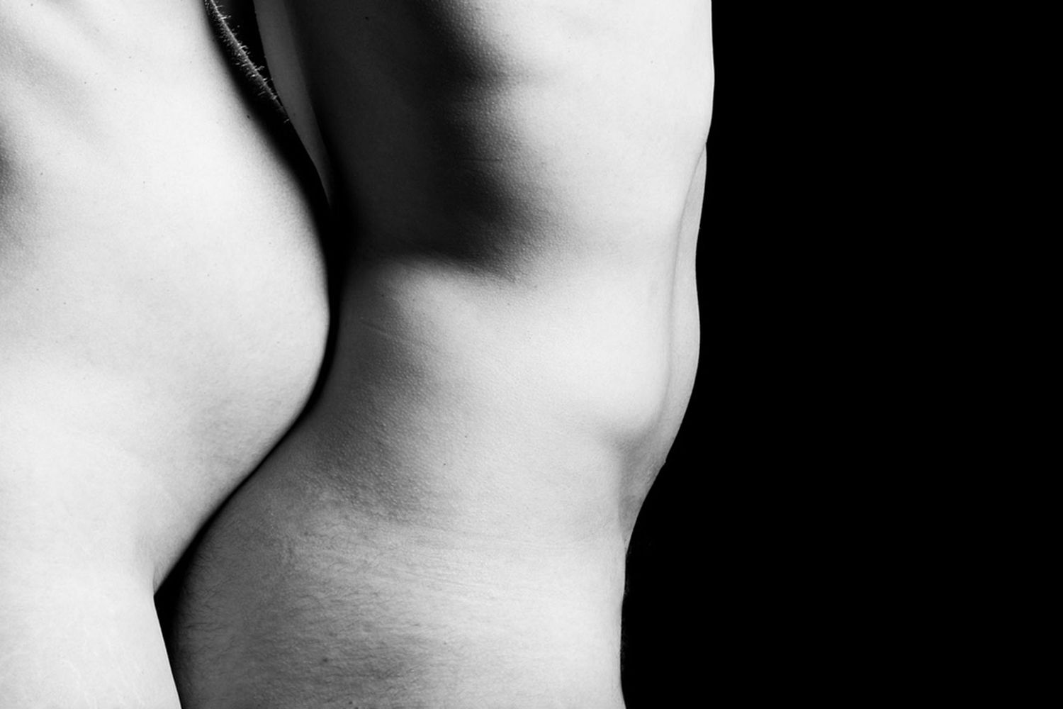 Abstract black and white photograph highlighting the curves and contours of human form.