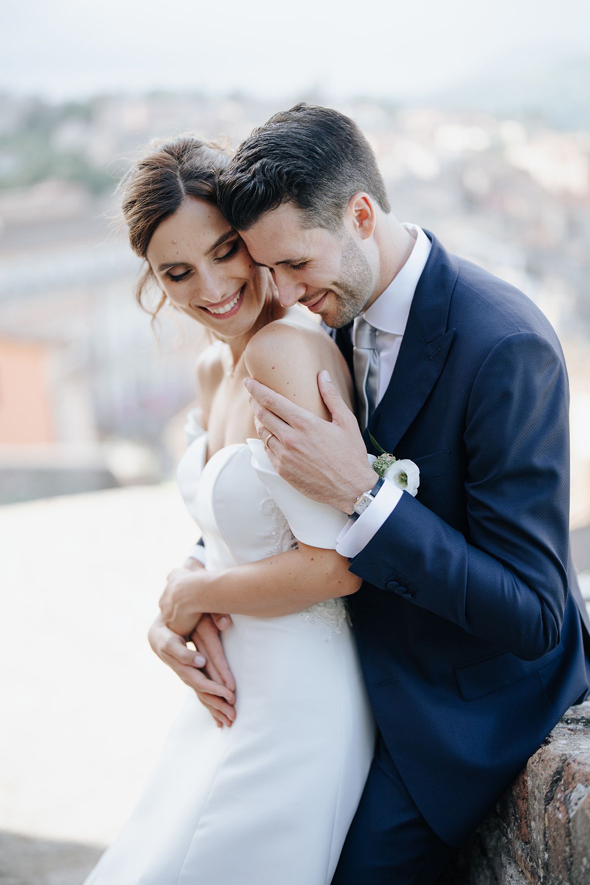 Intimate wedding portraits showing tender moments between newlyweds against soft white background.