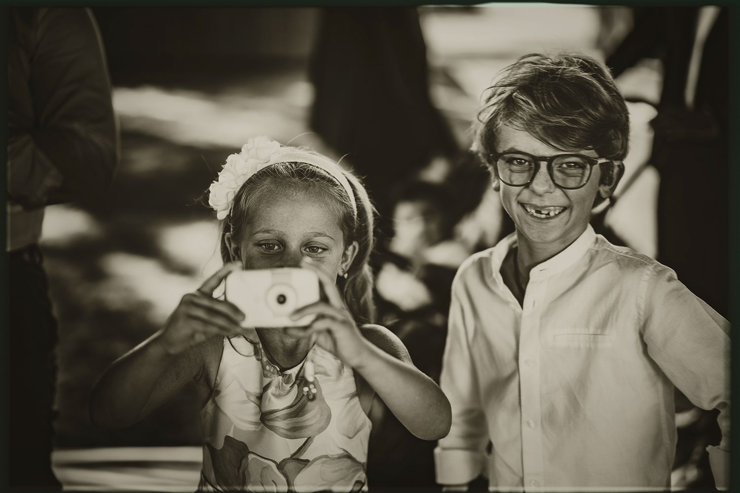 A black and white photo strip showing four sequential frames of people laughing and making expressions.