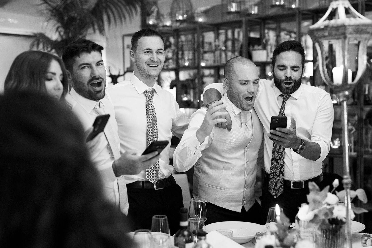 Candid black and white shots of wedding guests laughing and enjoying the reception.