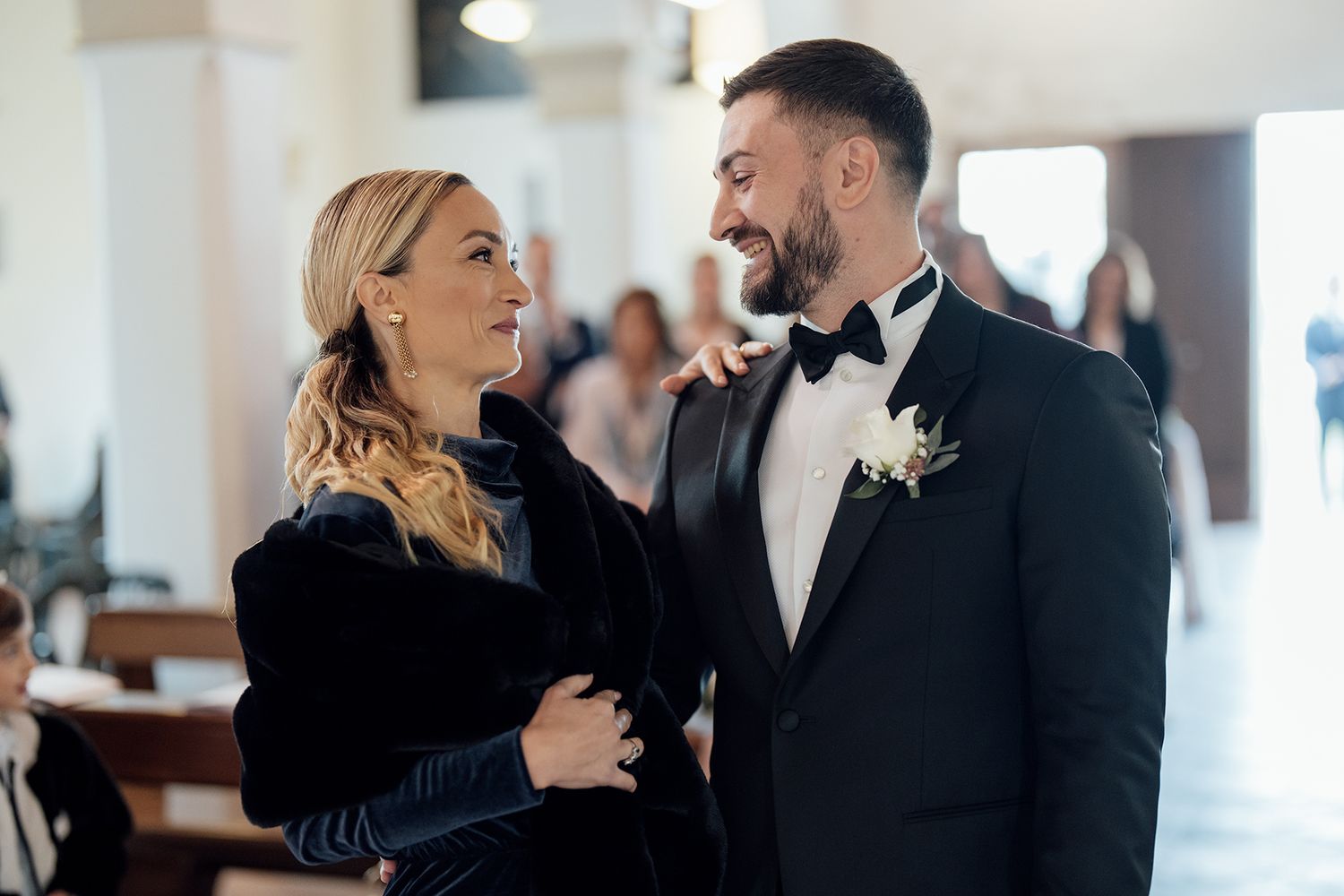 Intimate moment between couple in formal attire at wedding venue.