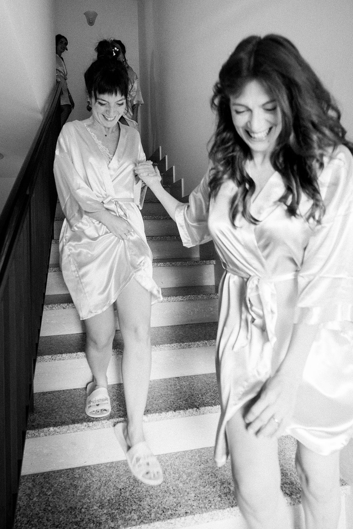 Series of black and white images showing movement in a white robe on stairs.