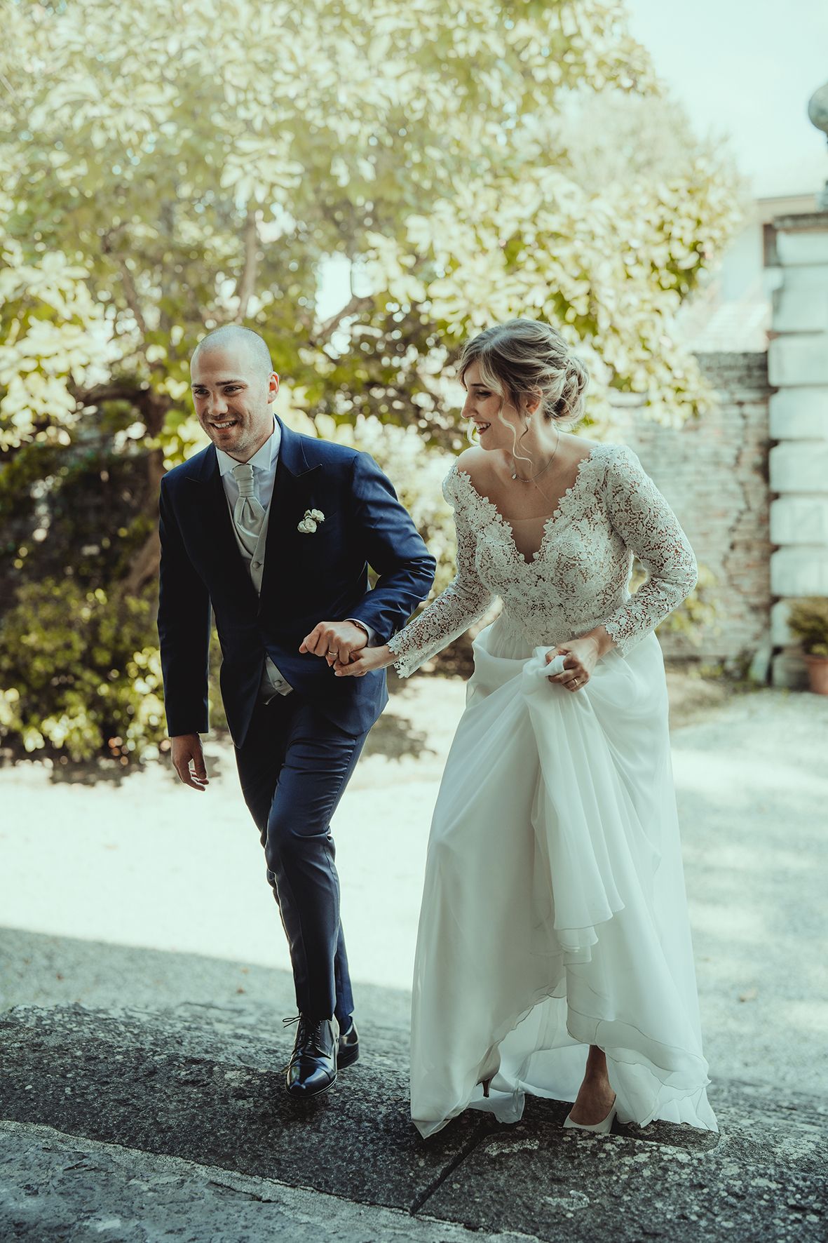 Joyful wedding couple runs together outdoors on their special day.