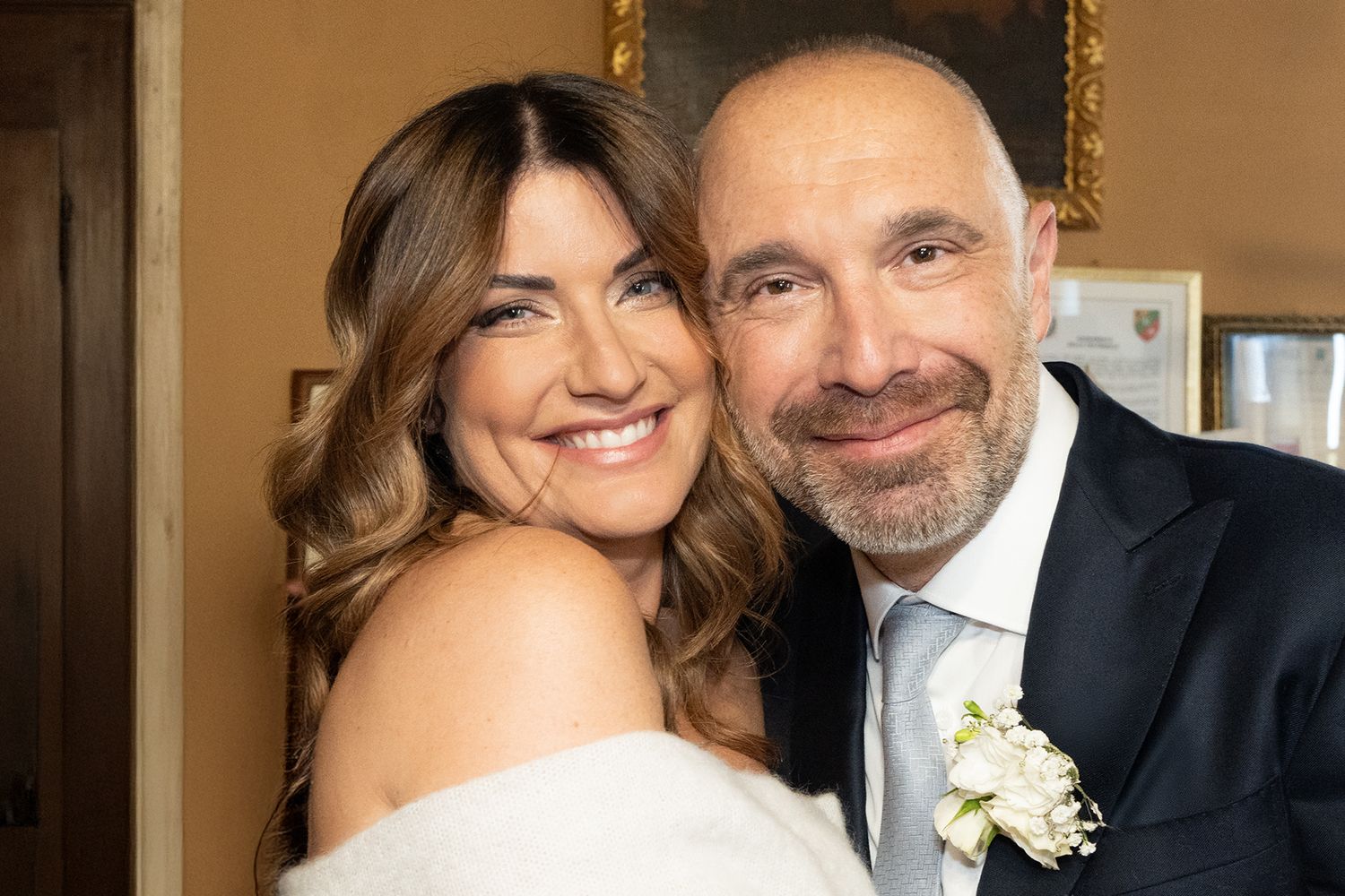 A happy wedding couple sharing a joyful moment in formal attire.