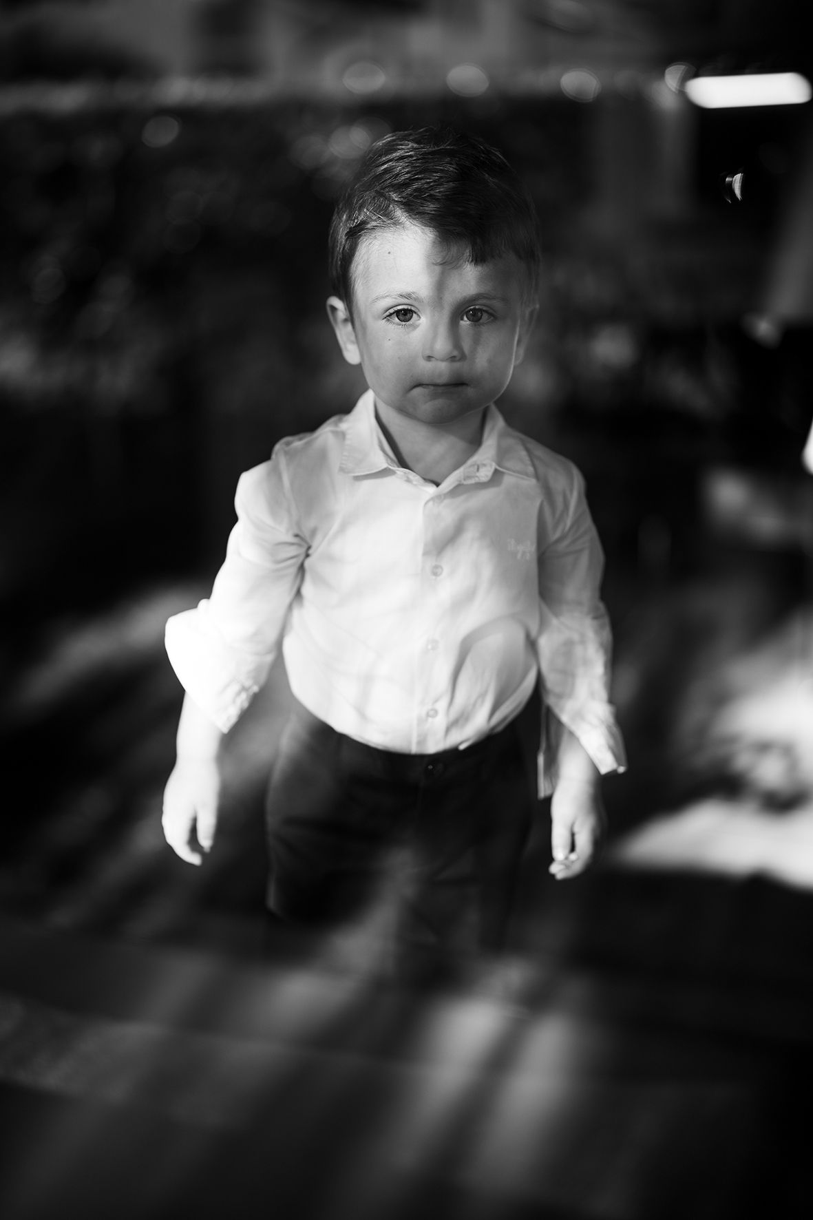 Black and white portrait showing person in white shirt against dark background.
