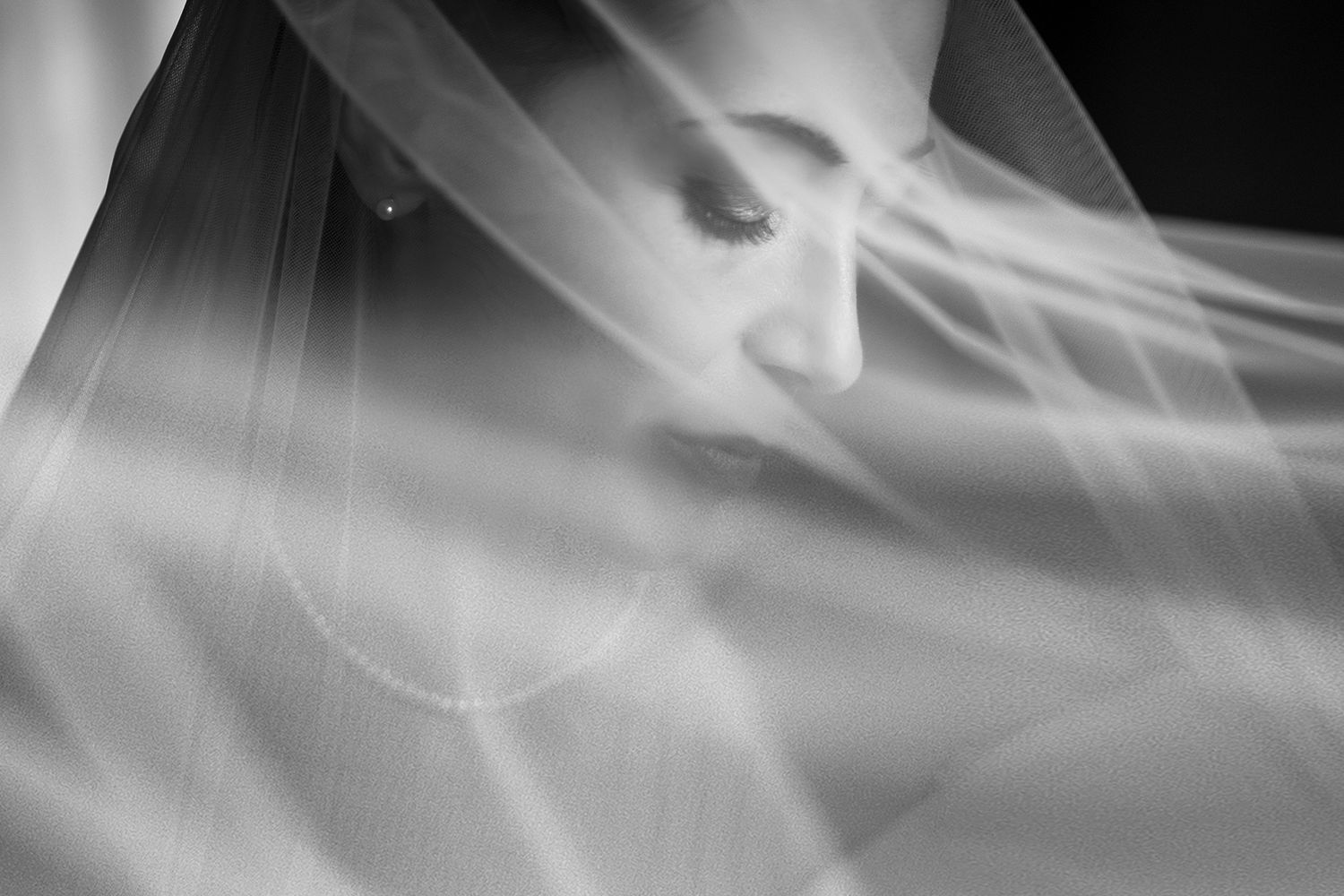 Artistic black and white close-up of flowing bridal veil creating ethereal effect.