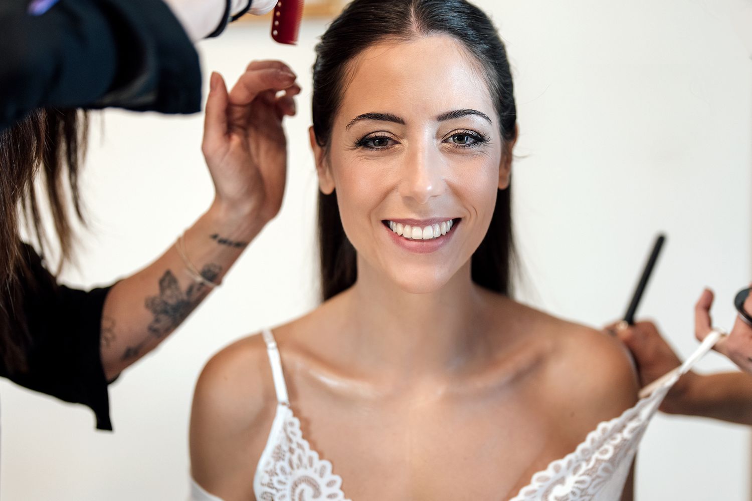 Bride getting her makeup professionally done while wearing a white robe on her wedding day.