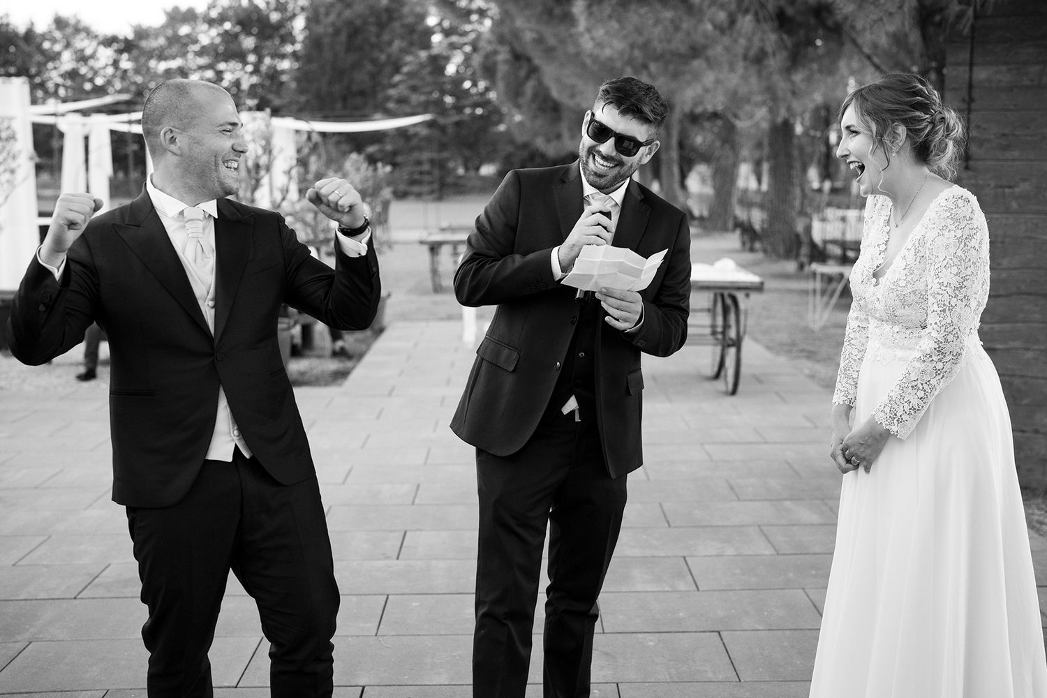 Wedding party sharing drinks and toasts during outdoor celebration.