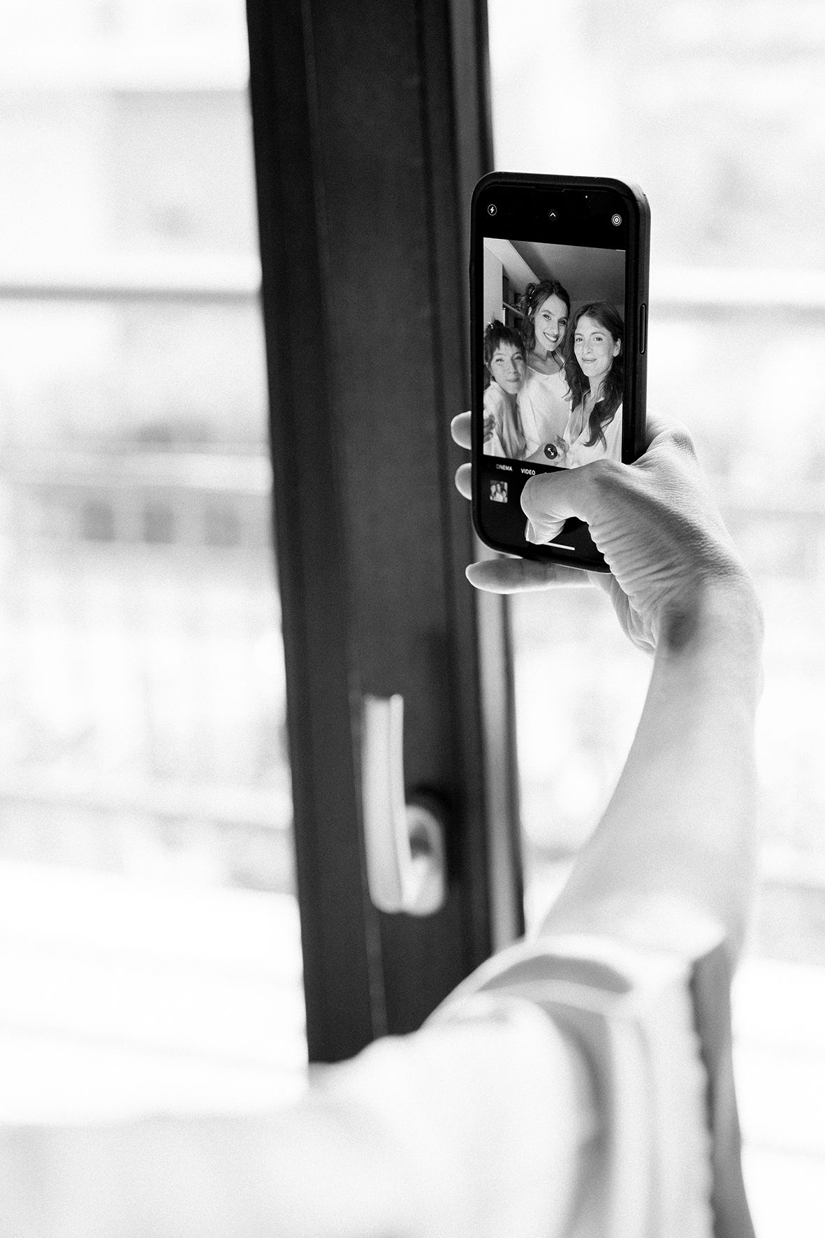 Black and white photo sequence of someone taking selfies with a phone.
