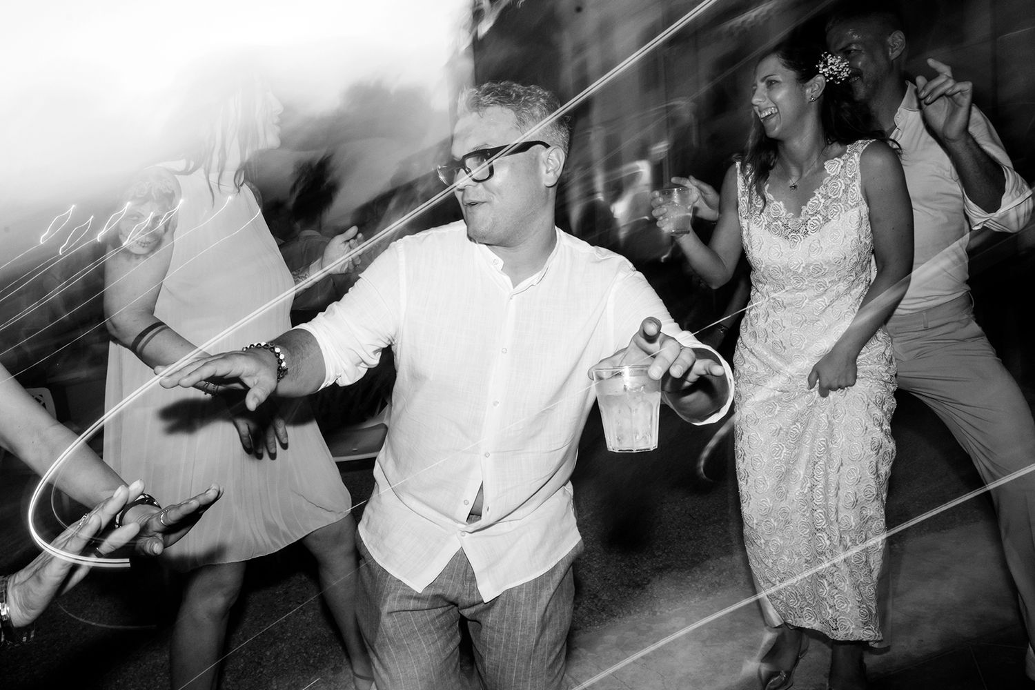 Dynamic dance floor scene with people moving and grooving in black and white.