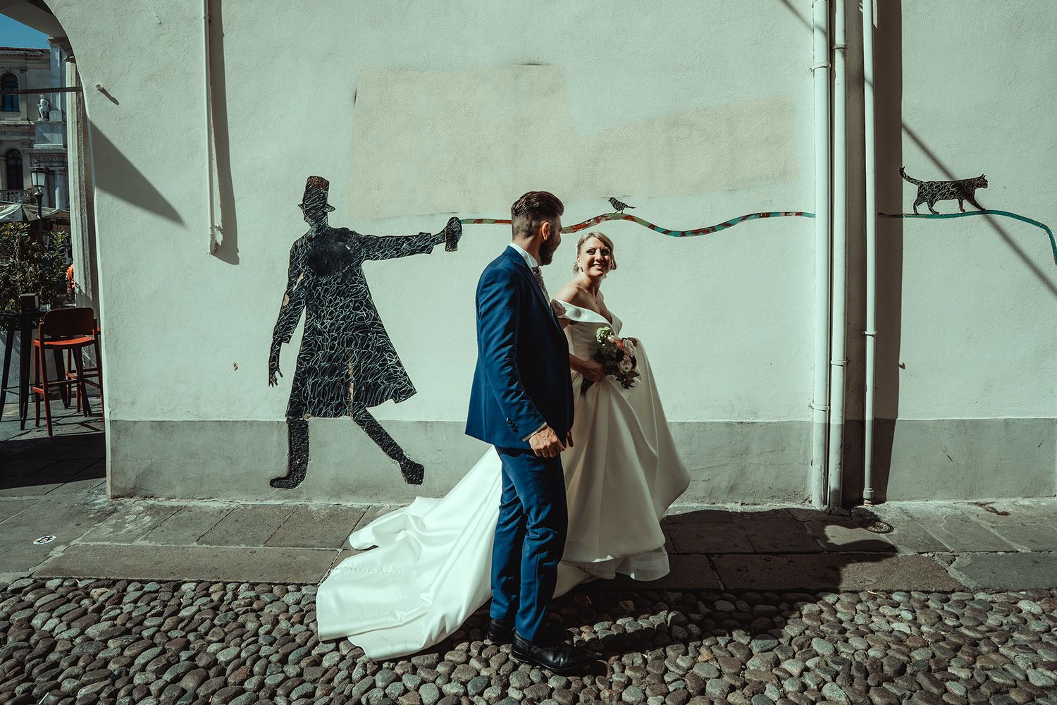 Playful wedding photo session against mint green walls and rustic architecture.