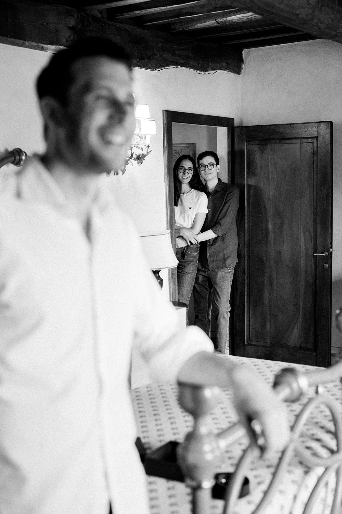 Black and white sequence showing a couple getting ready in a dimly lit room.