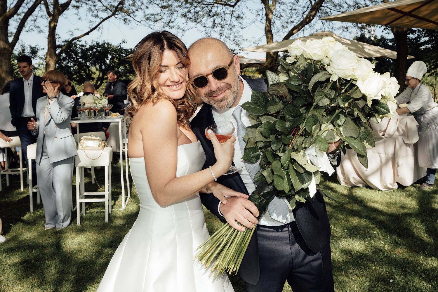 Elegant outdoor wedding ceremony with white floral arrangements and natural greenery.