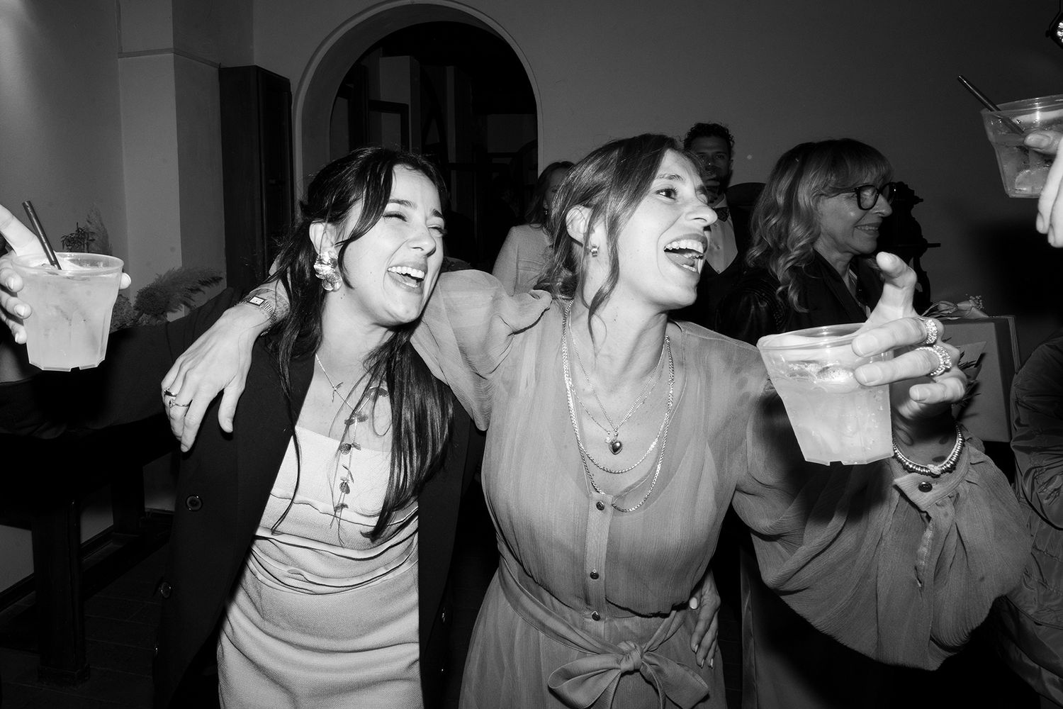 Black and white photos capturing spontaneous laughter at a wedding celebration.
