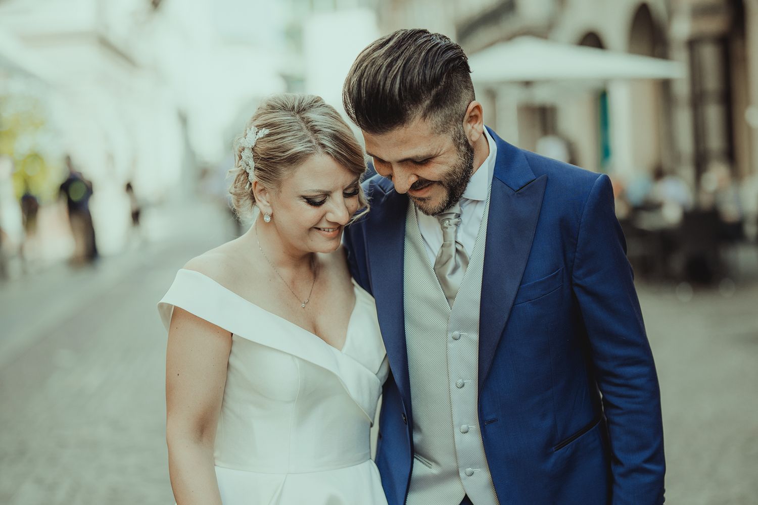 Wedding couple shares intimate moments on a historic European street.