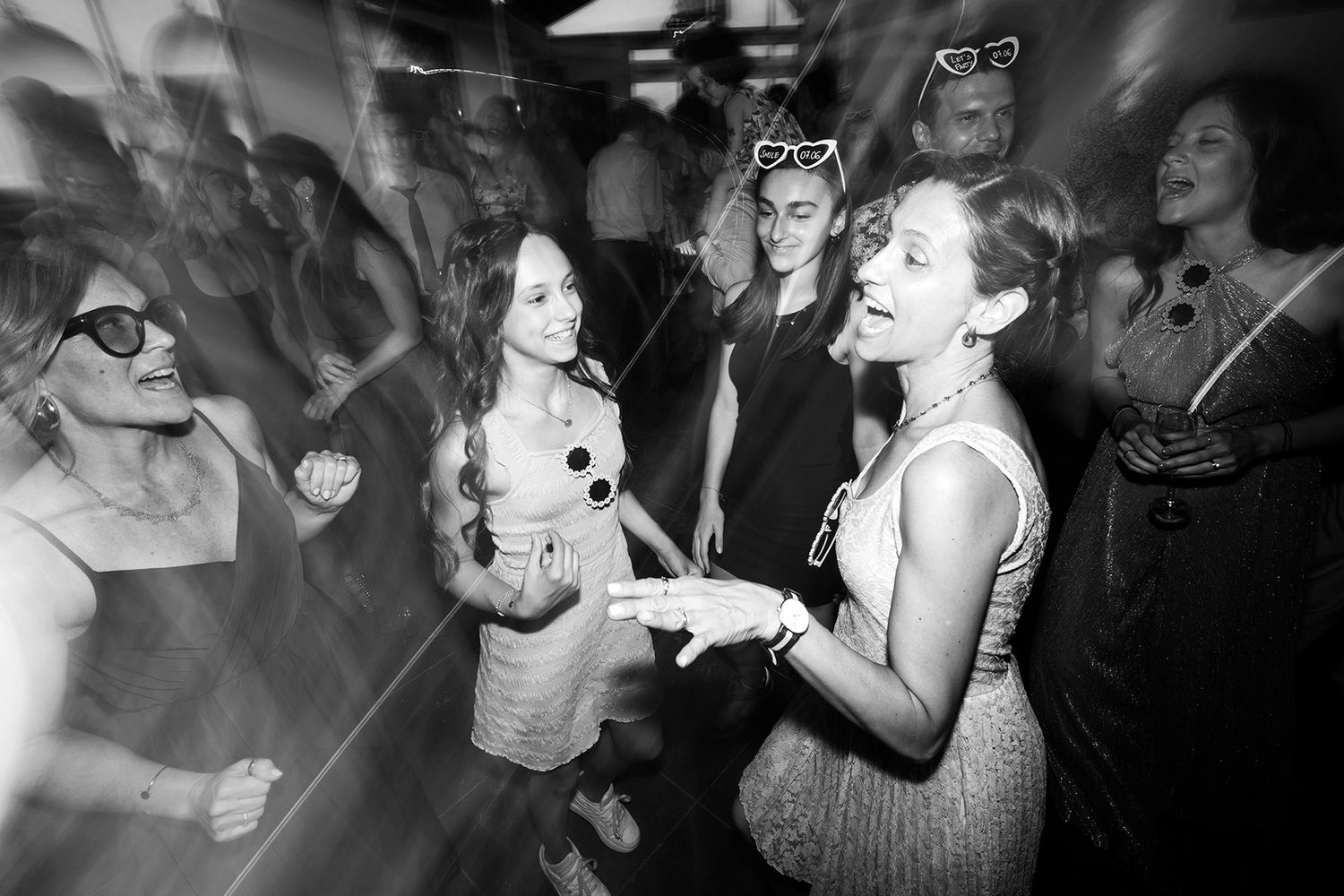 Black and white party scene with people dancing and celebrating in a lively atmosphere.