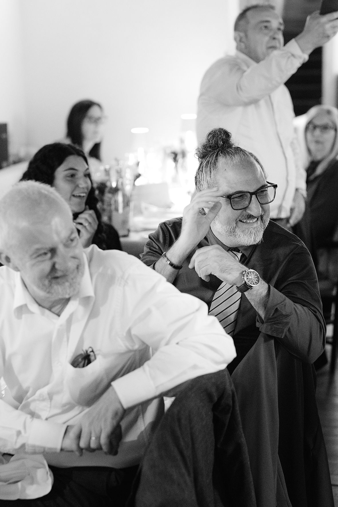 Black and white photos of wedding guests laughing and showing emotional reactions.