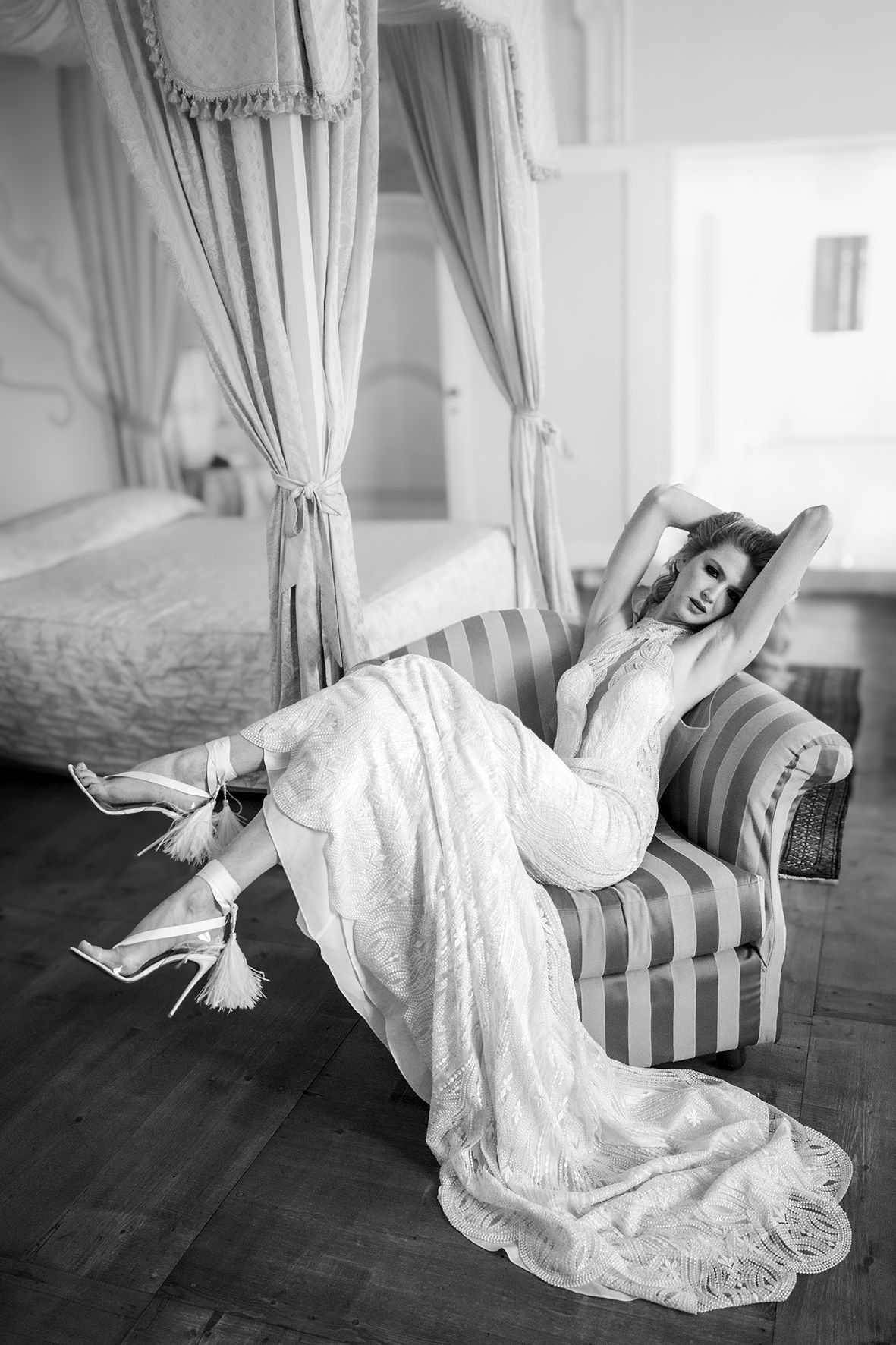 A series of black and white photos showing a person in a flowing white dress reclining dramatically on a striped chaise lounge.