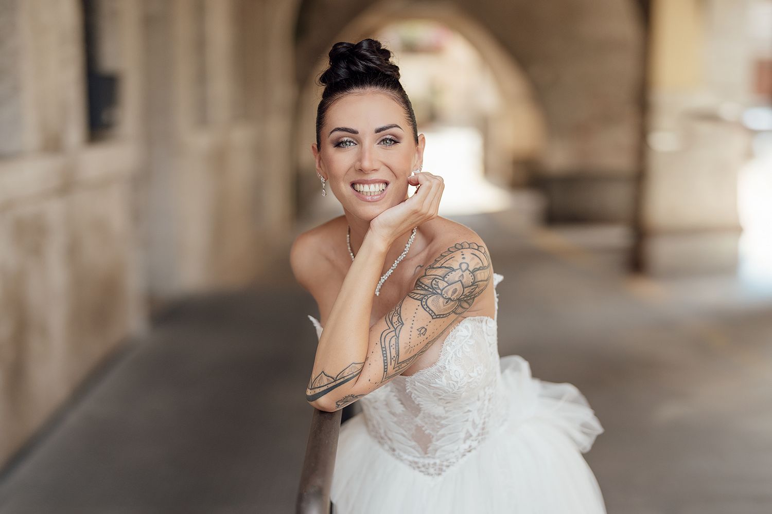 Romantic bridal portraits taken under stone archways with natural lighting.