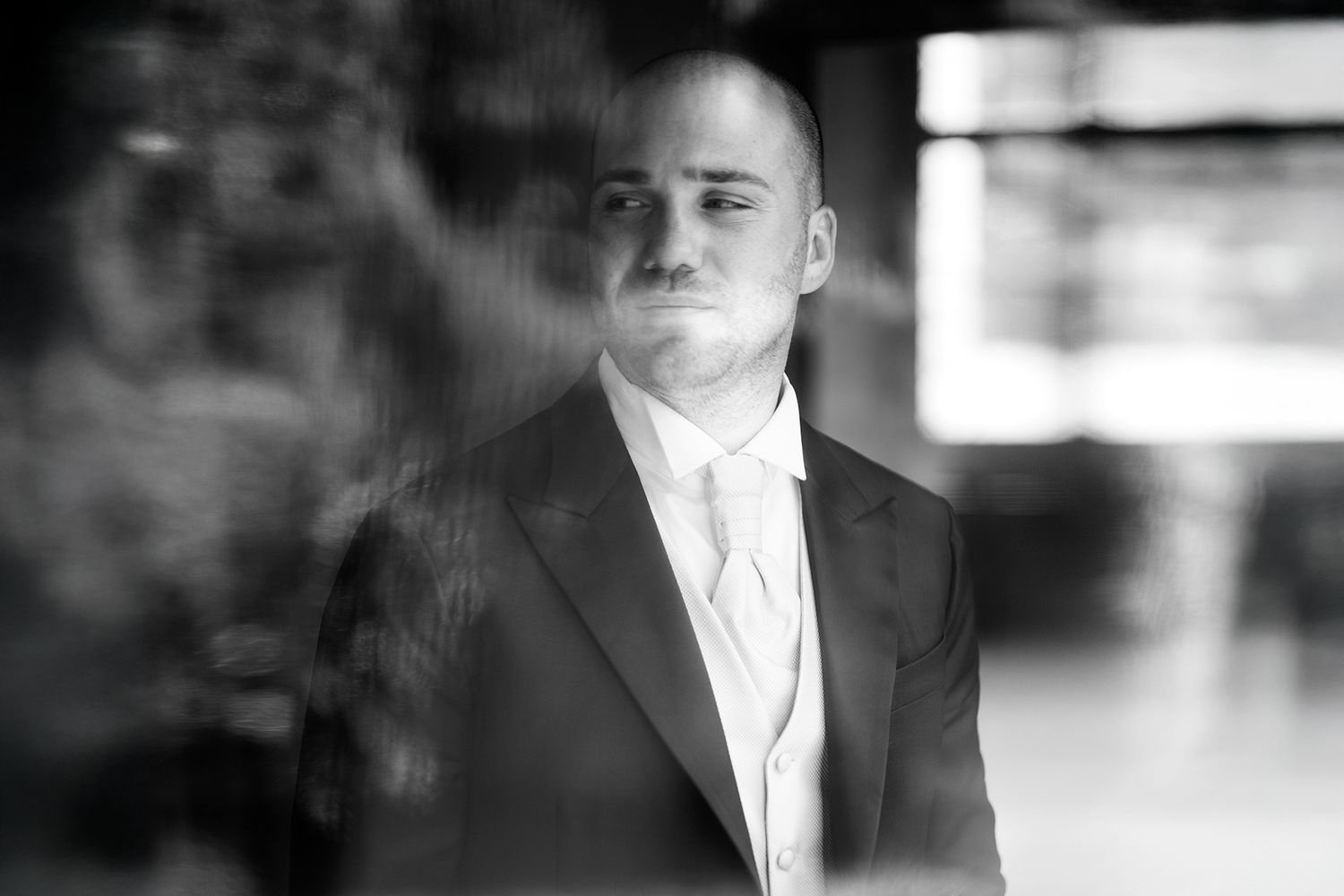 Classic black and white portrait of groom in formal attire.