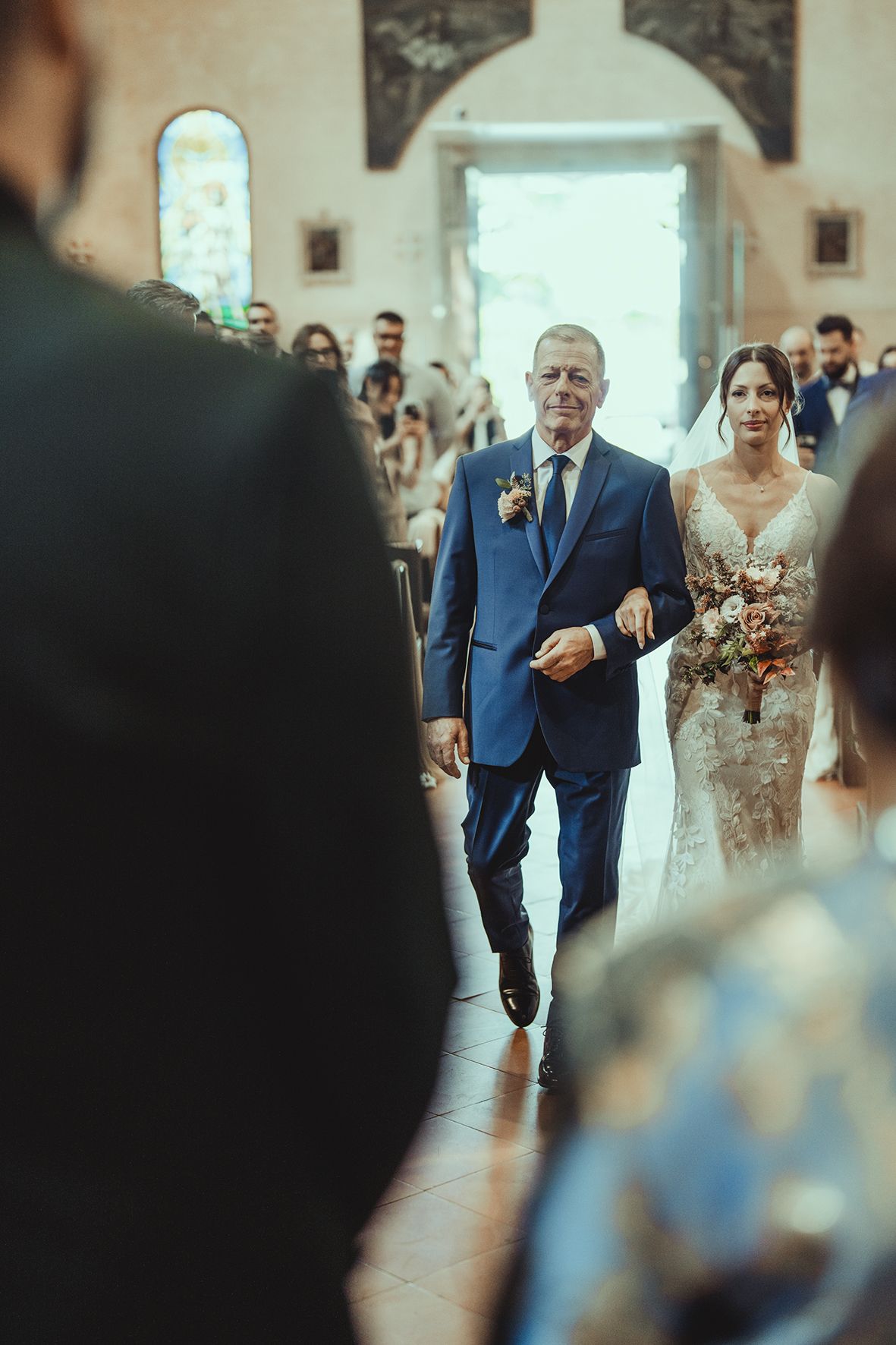 Wedding ceremony processional in a traditional church with stone interior.