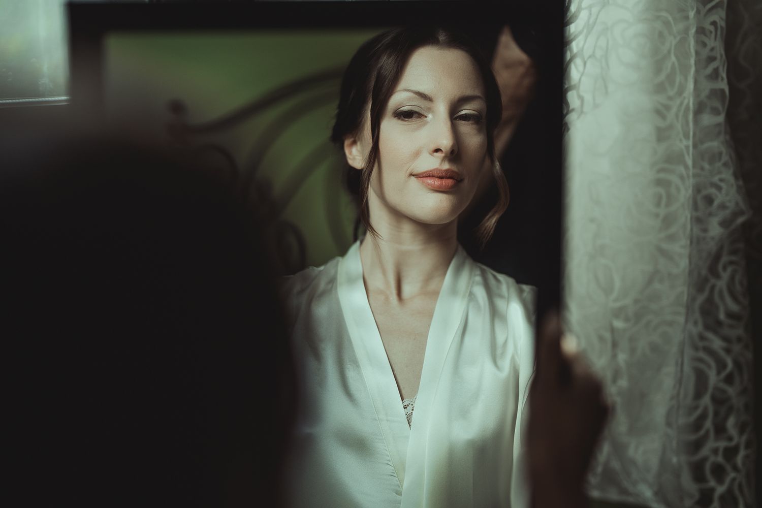 Atmospheric portrait in soft lighting with white lace curtains.