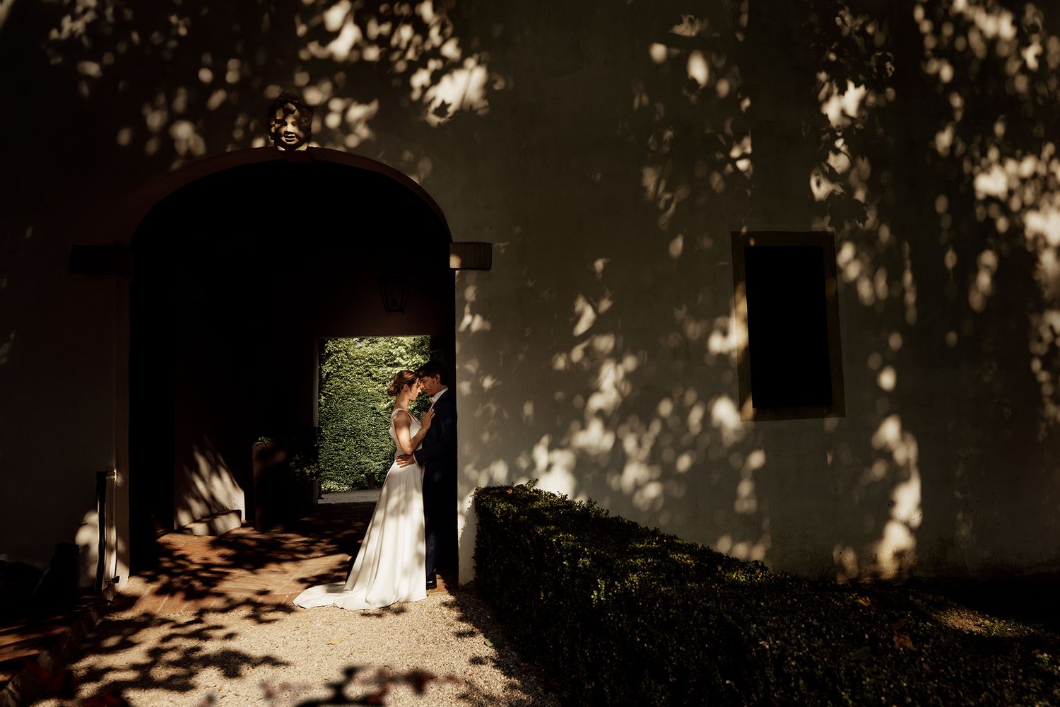 Wedding party guests dance and celebrate at an outdoor reception venue with trees in the background.