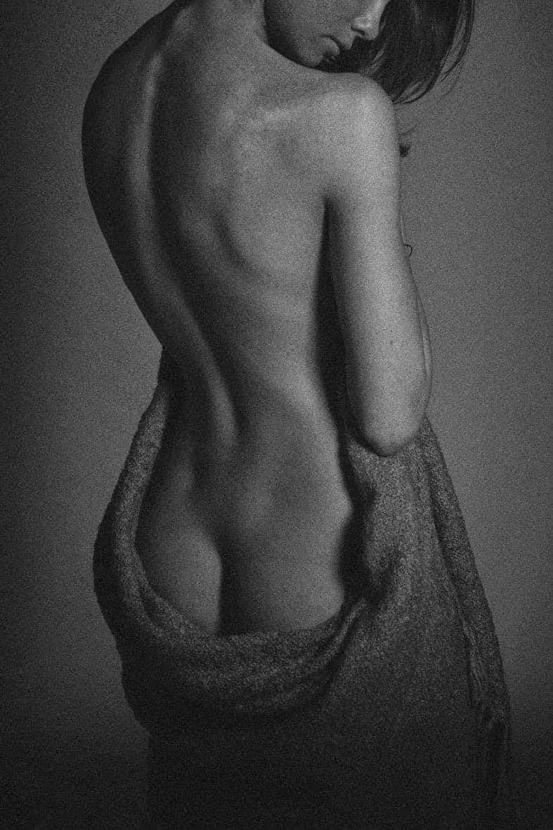 Artistic nude study in black and white focusing on back muscles and form.