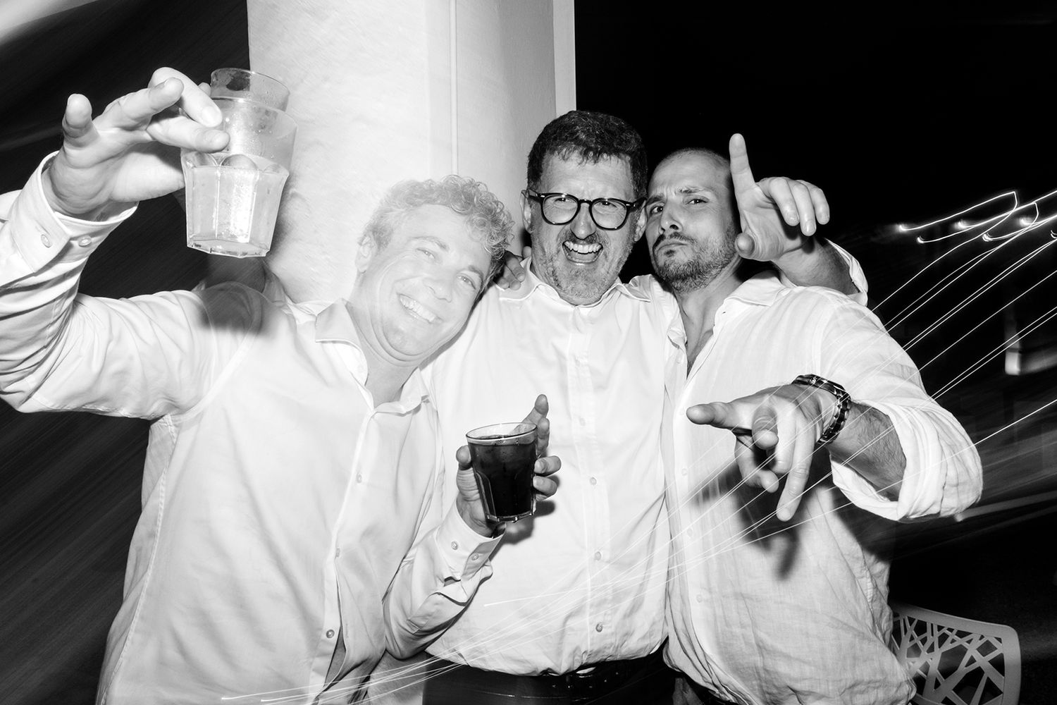 Black and white party sequence showing people in white shirts celebrating.