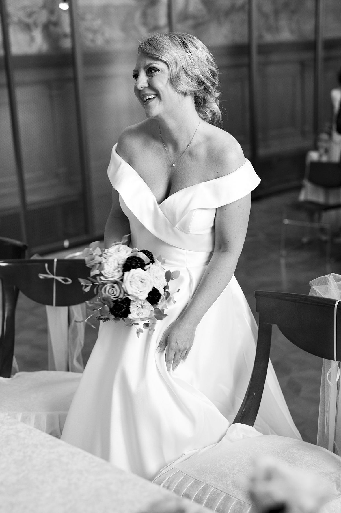 Elegant white wedding dress details shown in black and white photography.