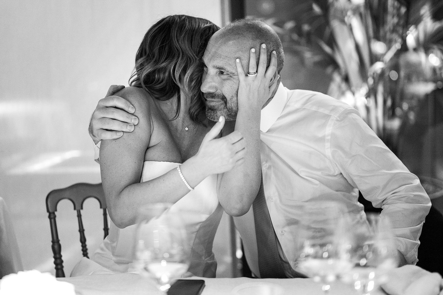 Candid black and white photos of wedding guests sharing joyful moments at reception.